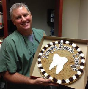 Sugar Land Prosthodontist, Stuart Rimes showing off his Boss's Day Cookie